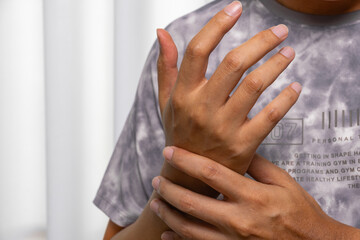 Close-up of hand gripping wrist—ideal for medical ads on wrist pain, joint inflammation, gout,...