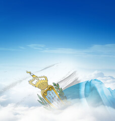 San Marino national flag waving in the clouds. The flag hiding in blue sky. San Marino national...
