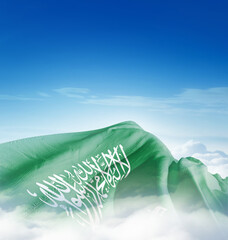 Saudi Arabia national flag waving in the clouds. The flag hiding in blue sky. Saudi Arabian...