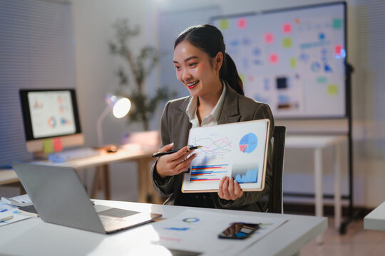 Young professional explaining financial data using charts and graphs during an online meeting in her office