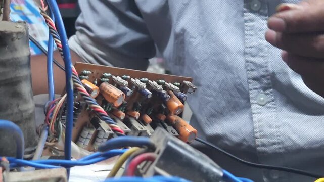 Electronics technician, electronic engineering electronic repair, electronics measuring and testing, repair and maintenance, mechanic working with parts in local shop in India, Odisha