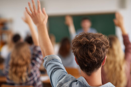 A classroom with a teacher and students raising their hands