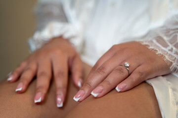 Bride's hand with elegant diamond engagement ring.