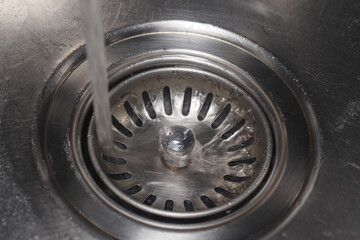 Water flowing into a stainless steel sink drain