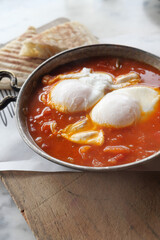 Savory poached eggs in spicy tomato sauce with bread