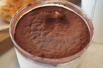 Delicious dessert with cocoa powder topping at cafe table