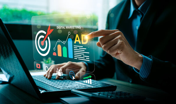 Digital marketing strategy and online advertising concept with businessman typing on laptop and hologram interface showing target, analytics graph, social media, and campaign management tools