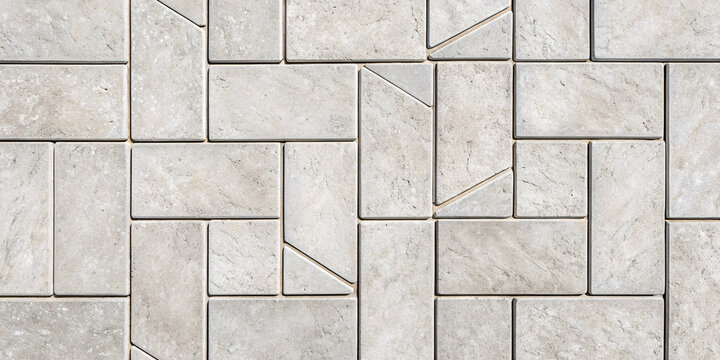 Light grey limestone tiles with geometric triangular inlays creating modern chevron accents within rectangular stone layout