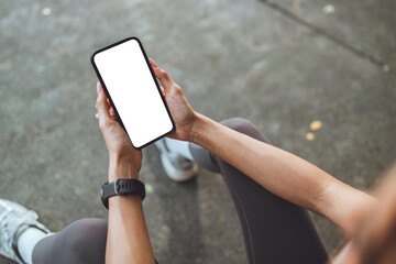 Hand of sports woman holding smartphone with blank white screen for copy space, mobile fitness app...
