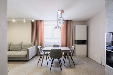 modern living and dining area. It features a sofa, dining table with four chairs, curtains, and a modern chandelier
