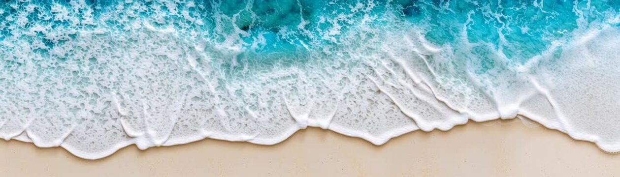 Expansive sandy shoreline meets the rhythmic dance of ocean waves under a clear sky creating a serene and tranquil coastal landscape scene.