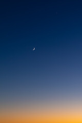 Crescent moon at sunrise over Long Bay, Auckland