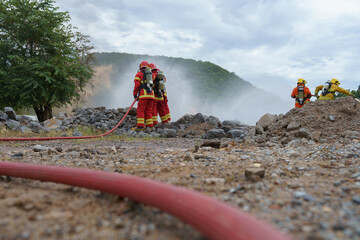 Firefighters are working together to put out the fire with water.