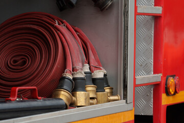 Close to the pipes and fire hoses, they are working together to put out the fire with water.