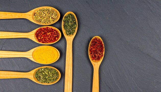 Overhead View of Spoons Filled with Spices on Dark Slate