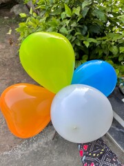 Hand Holding Four Colorful Balloons on White Background – Party Decoration Concept