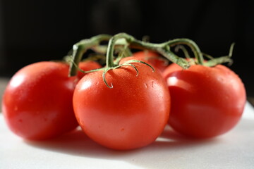 Close-up of fresh vine tomatoes, highlighting quality and variety found in supermarkets, grocery stores, and local farms. Perfect for food marketing, retail, and agricultural topics.