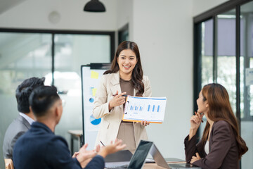Group of Asian business people meeting and presenting work in the office	
