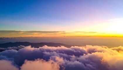 Sunrise over mountaintops shrouded in clouds
