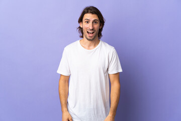 Young handsome man isolated on purple background with surprise facial expression