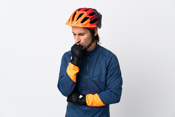 Young cyclist man isolated on white background having doubts