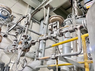 Obraz premium An intricate web of industrial pipes and valves fills the frame, showcasing the complexity of factory automation. This image is a great representation of modern engineering, technology.