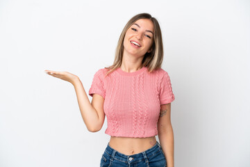 Young Romanian woman isolated on white background holding copyspace imaginary on the palm to insert an ad