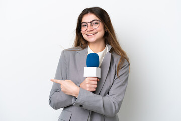 Young caucasian TV presenter woman isolated on white background pointing finger to the side