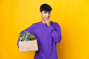 Man making a move while picking up a box full of things having doubts and thinking