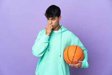 Young man playing basketball over isolated purple background having doubts