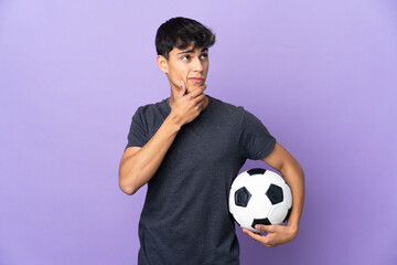 Young football player man over isolated purple background having doubts