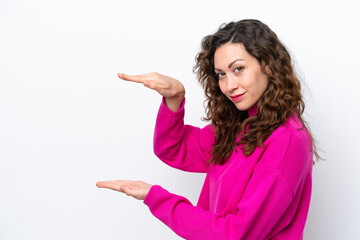 Young caucasian woman isolated on white background holding copyspace to insert an ad
