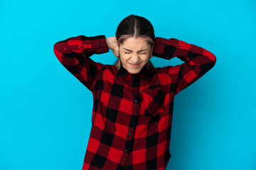 Young caucasian woman isolated on blue background frustrated and covering ears