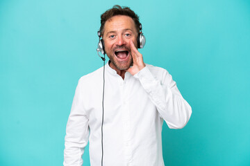 Telemarketer caucasian man working with a headset isolated on blue background with surprise and...