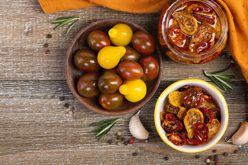 Flat lay photo of a glass jar and and saucer with sun dried red and yellow tomatoes in olive oil...