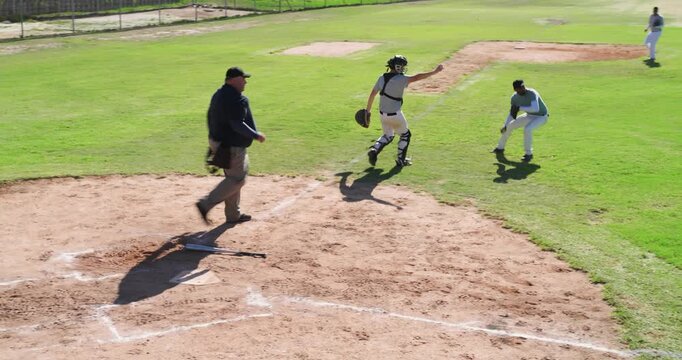 After umpire signaling strikeout, Diverse male teammates celebrating around home plate at field