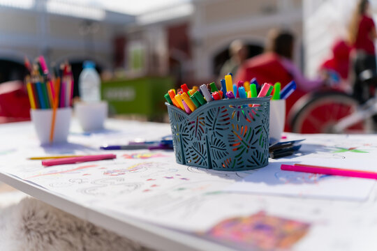 Creative art workshop table with colorful felt tip markers, drawing paper and sketches, kids outdoor activity station at summer event, tools for painting, drawing, coloring and crafts