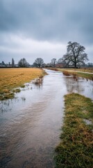 Flooded Countryside Field With Overflowing River And Overcast Sky. Rural Landscape During Rainy Season