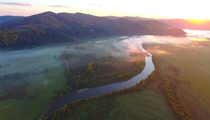 Aerial view of a meandering river winding through a valley at sunrise