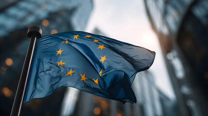 A close-up view of the European Union flag waving in the breeze, set against a backdrop of modern glass buildings and a dramatic sky, symbolizing unity, progress, and collaboration in Europe.