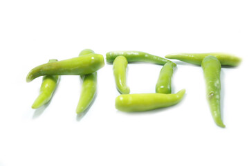 Fresh large green chillies cultivated by farmers for sale and self-eating - for seasoning and appetizing food on a white background with local hot letters.