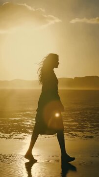 Golden Hour Cinematic Silhouette of Woman Walking Along Reflective Shoreline at Sunrise &ndash; Elegant Slow-Motion Stock Video for International Women&rsquo;s Day, Mindfulness, and Lifestyle Travel Footage