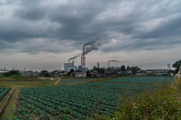 Smoke is coming out of the factory's chimney on the outskirts of Yatsushiro City, Japan.