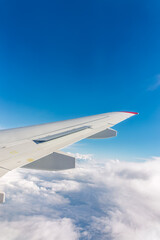View from the airplane window at a beautiful cloudy sky and the airplane wing