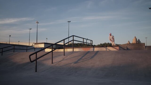 Skilled rollerblader skates along metal railing in extreme park