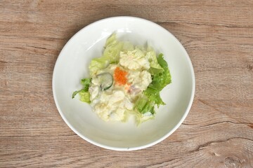 baked potato with cabbage topping egg shrimp salad dressing sauce on plate
