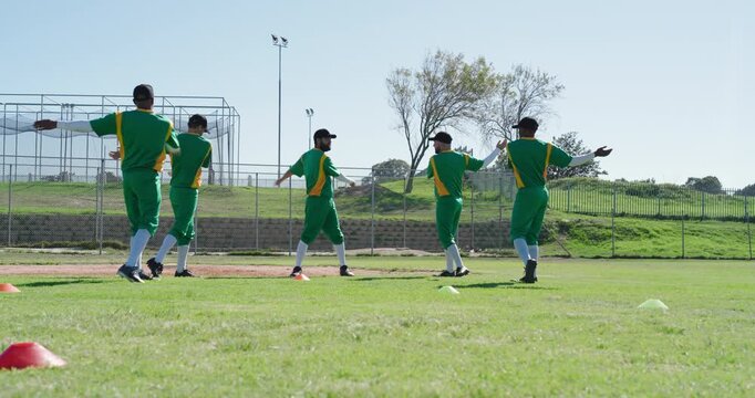 Swinging, bending five male cricket players in green jerseys warming up on cricket field by cage