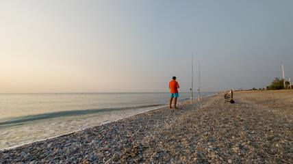 Pescador en la playa al amanecer.
