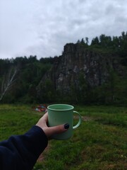 Obraz premium Morning Calm Cup of Tea in Nature with Mountain View, Refreshing Outdoor Moment. Serenity