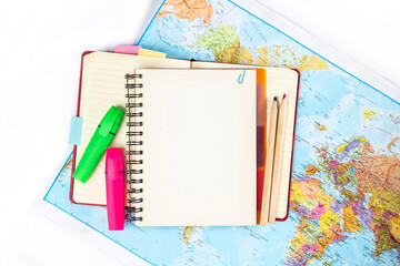 Notebook with mock up page, notebook and textbooks on the world map. Concept of world economy and...